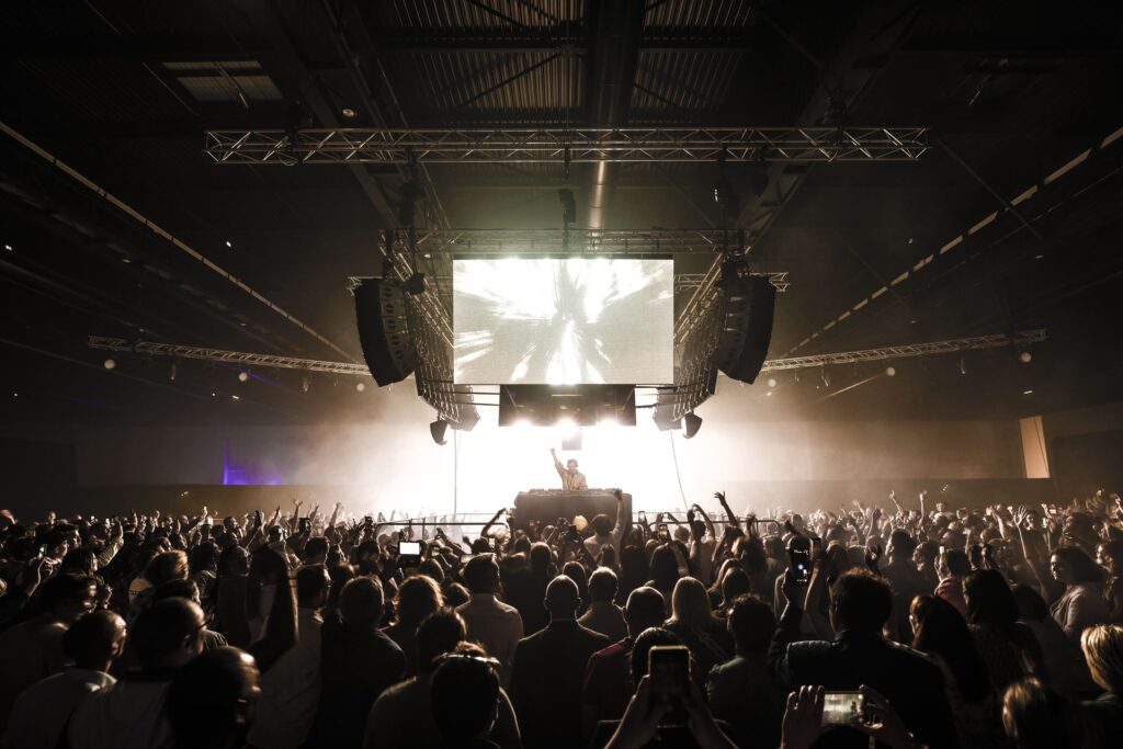 DJ jouant devant une foule enthousiaste en concert.